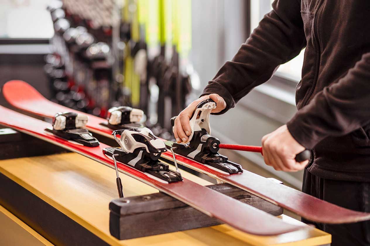 Technician adjusting ski bindings on the workshop bench